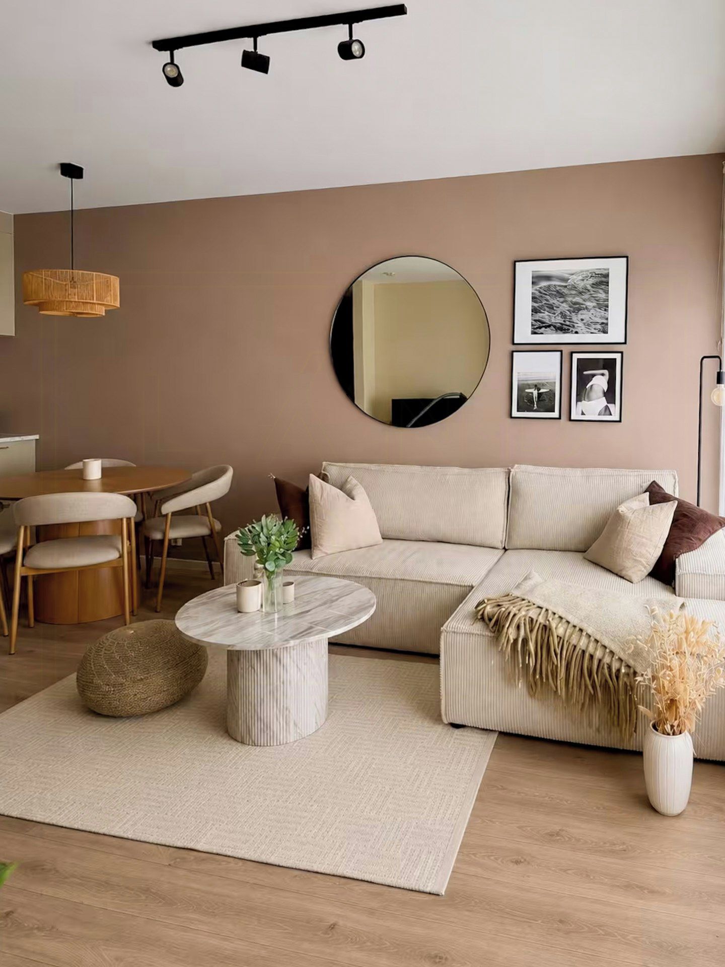 A modern living room with a sofa, round coffee table, and a dining area with chairs.