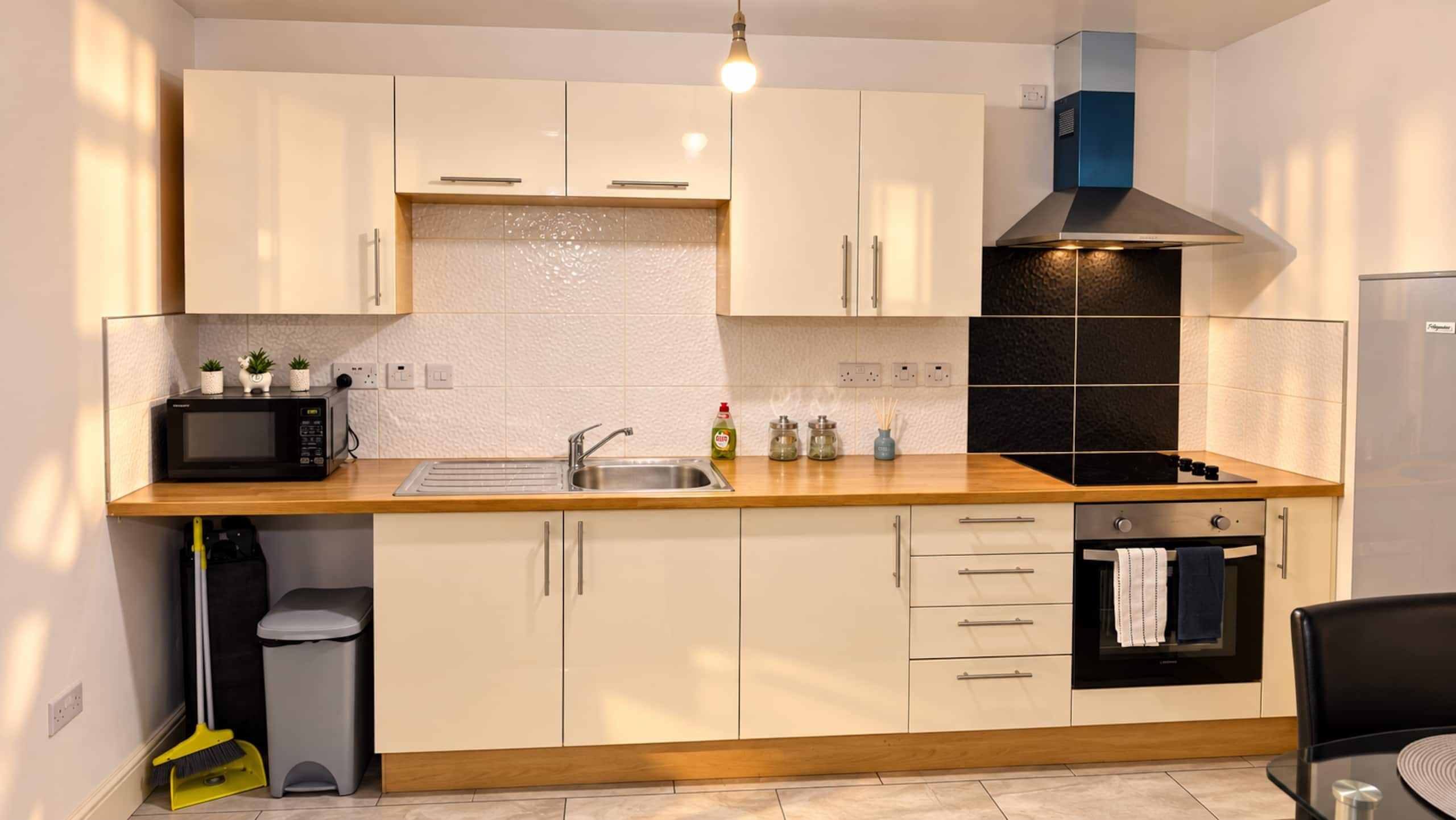 A modern kitchen with a microwave, sink, stove, and cabinets.