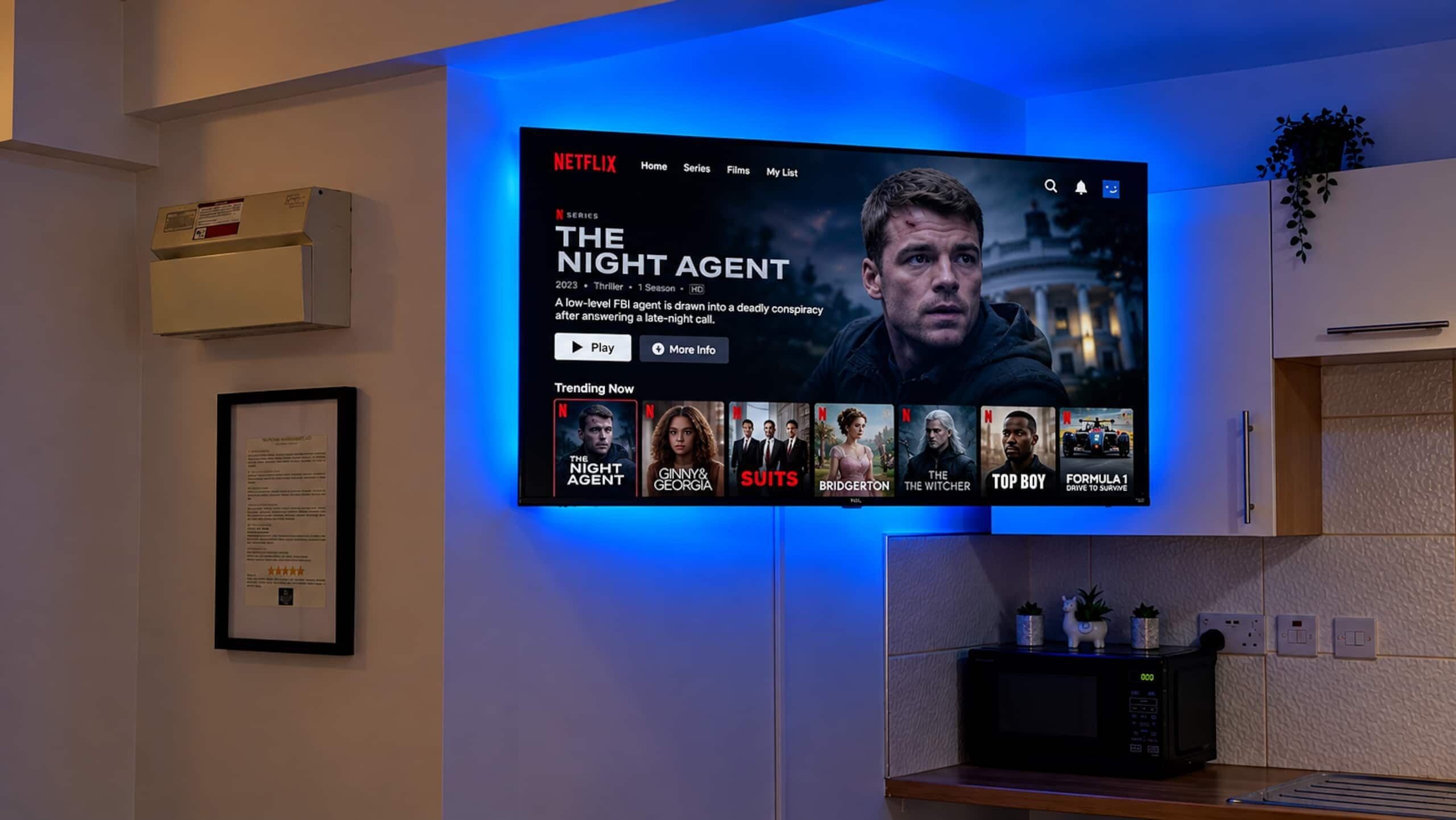Un televisor de pantalla plana montado en la pared mostrando la interfaz de Netflix con 'The Night Agent' en destaque.