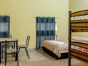 A room with a bed, a chair, a table, and a curtain. - Patagonia Hostel (Asunción)