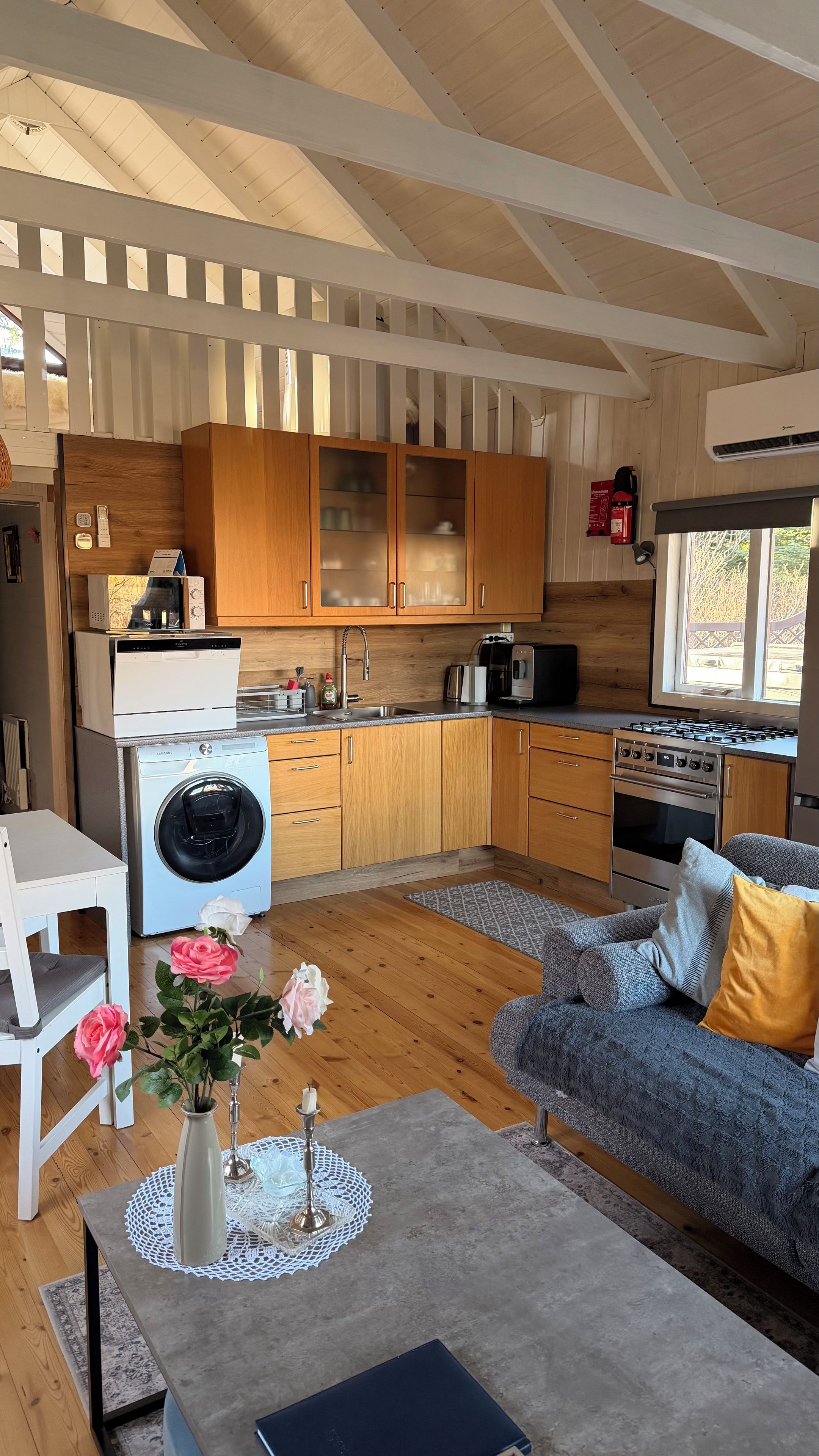 A compact kitchen with wooden cabinets, a built-in washing machine, and a stove.