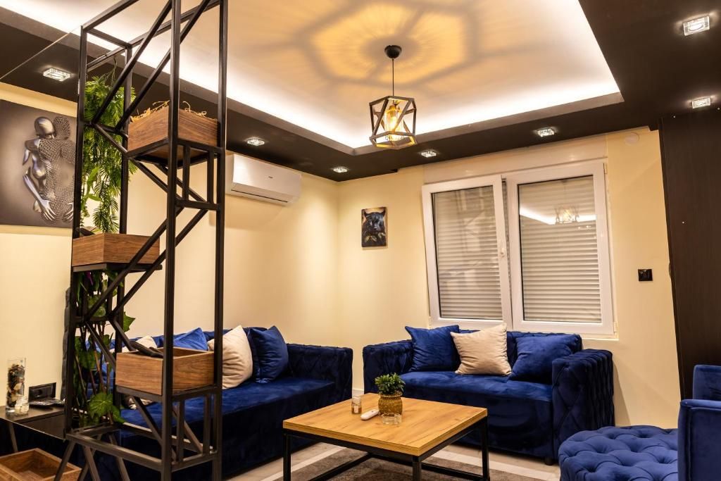 Una sala de estar moderna con un sofá azul, una mesa de centro de madera y una planta decorativa.