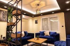 Un salon moderne avec un canapé bleu, une table basse en bois et une plante décorative.