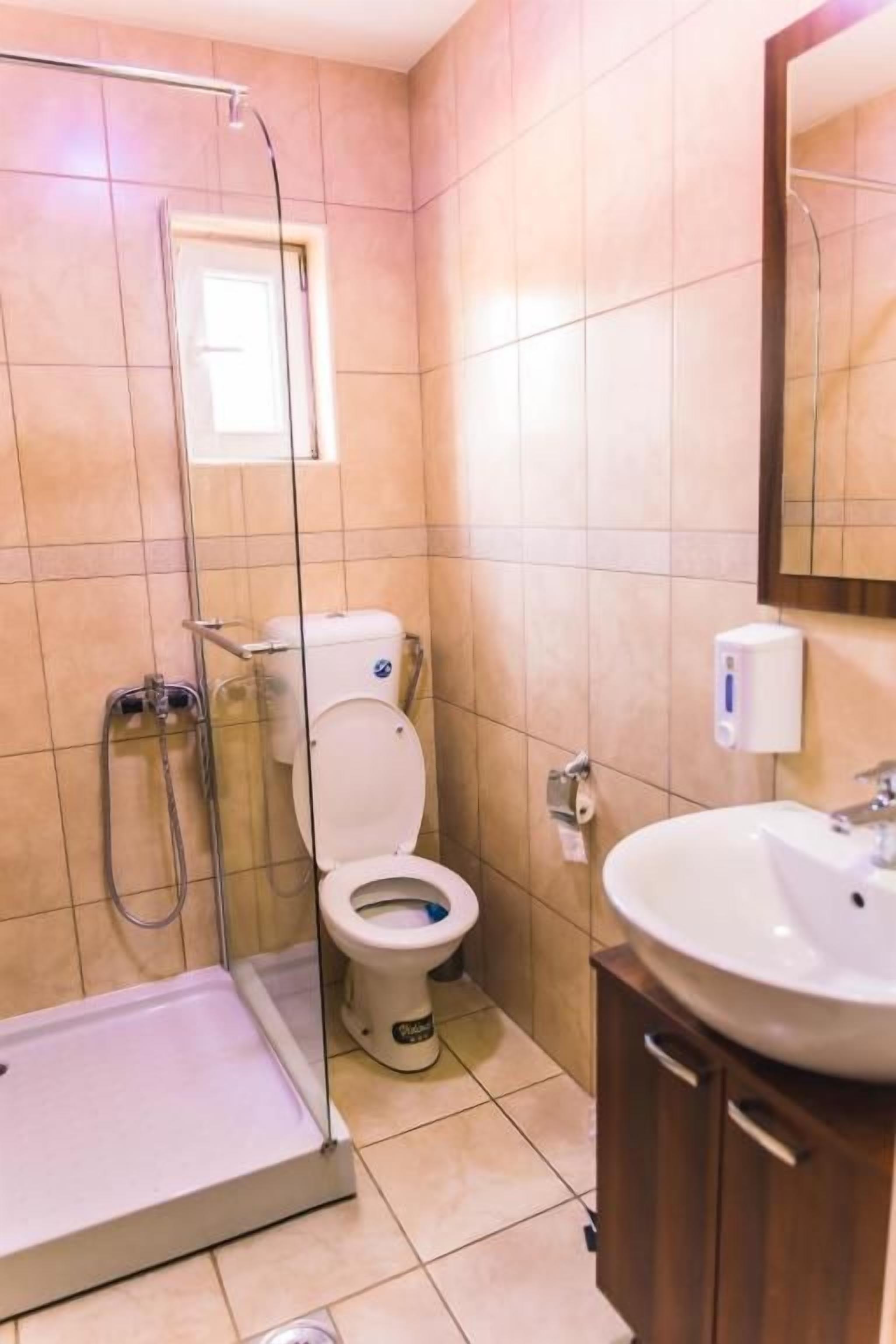 Un bagno con doccia, WC e lavabo.