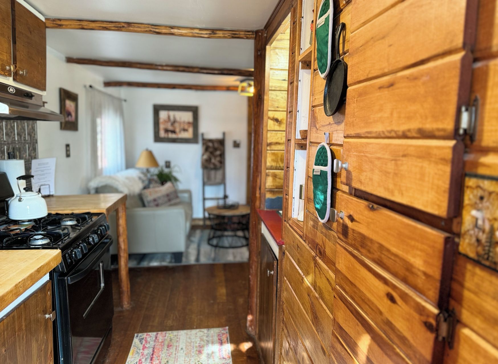 A kitchen with wooden cabinets, a stove, and a dining area with a table and chairs.