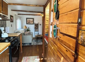 Une cuisine avec des meubles en bois, une cuisinière et un coin repas comprenant une table et des chaises.