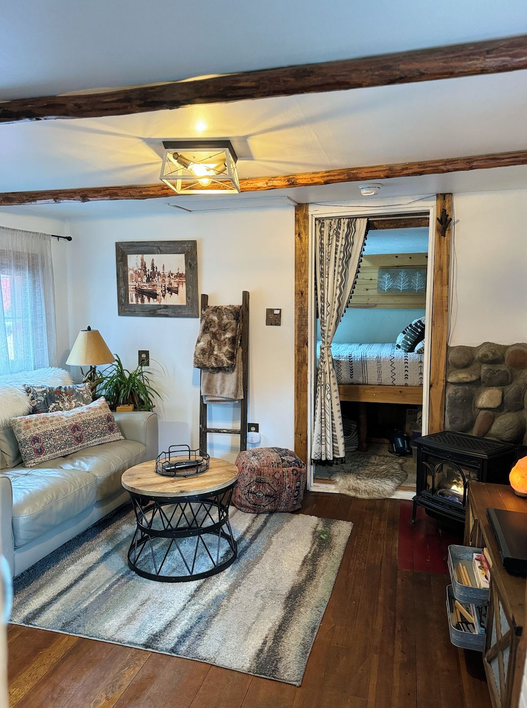 A cozy living room with a sofa, a round coffee table, and a fireplace.