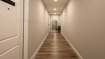 Un pasillo con piso de madera, paredes blancas y una puerta con la leyenda 'STINGRAY STAY'.