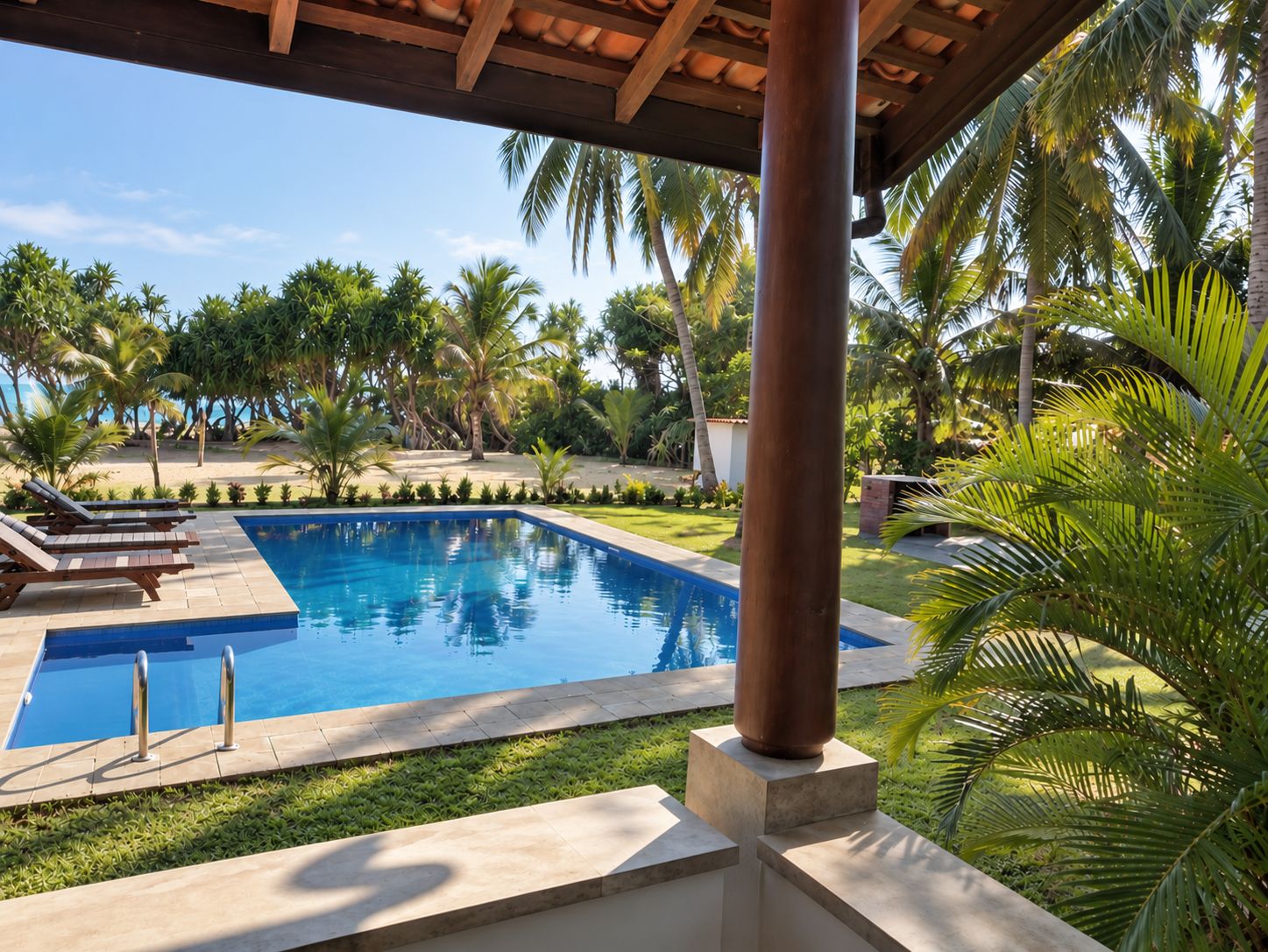A rectangular swimming pool with a clear blue water surface, surrounded by a well-maintained lawn and palm trees.