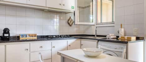 A kitchen with white cabinets, a stove, a sink, and a dishwasher.
