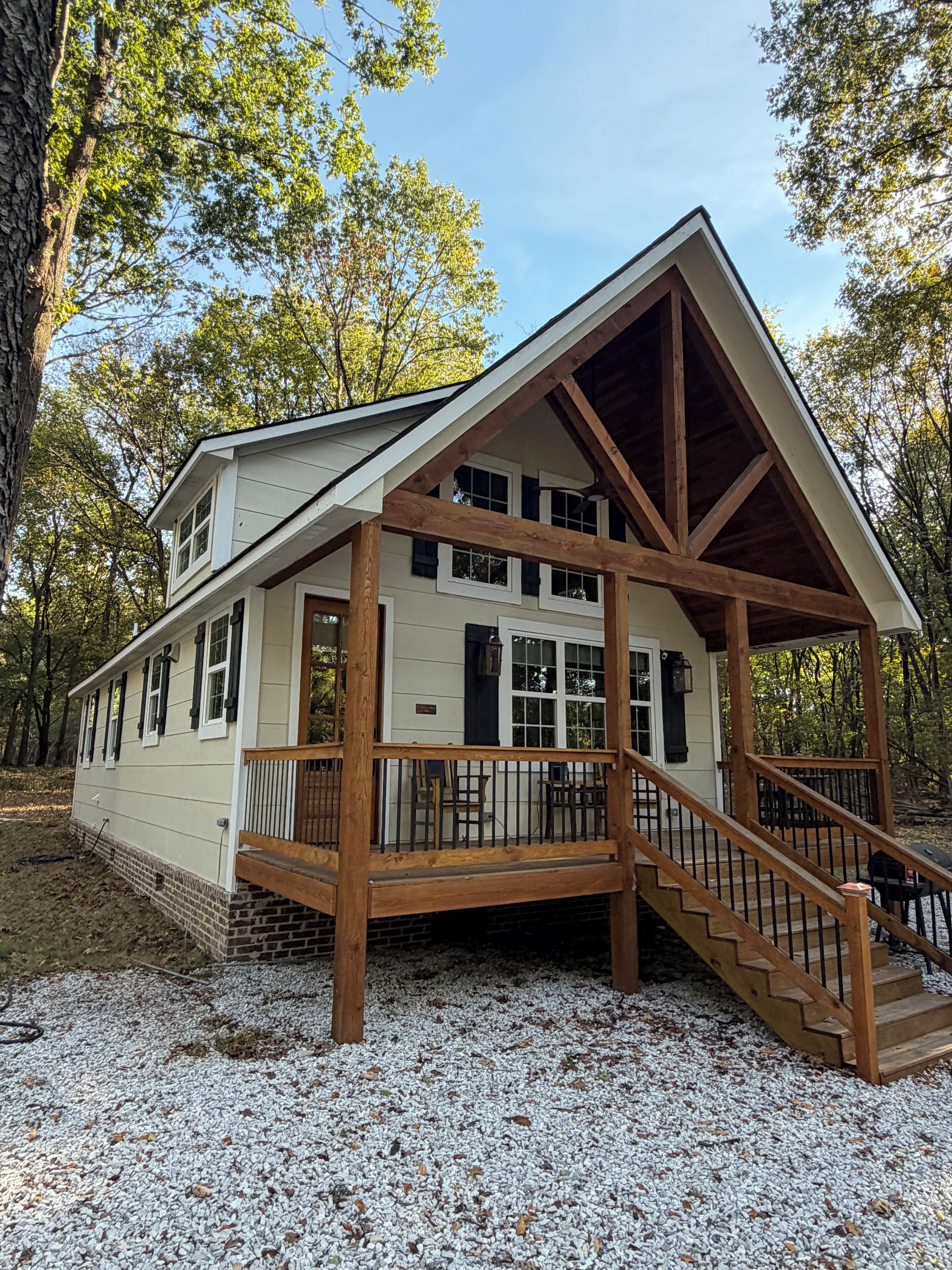 A two-story building with a covered porch and a staircase leading to the upper level.