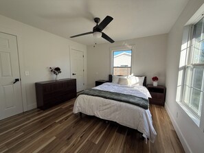 A bedroom with a bed, dresser, nightstands, a ceiling fan, and a window. - 4BR, 2 Suites & Covered Deck, Edge Of Springfield (Ozark)