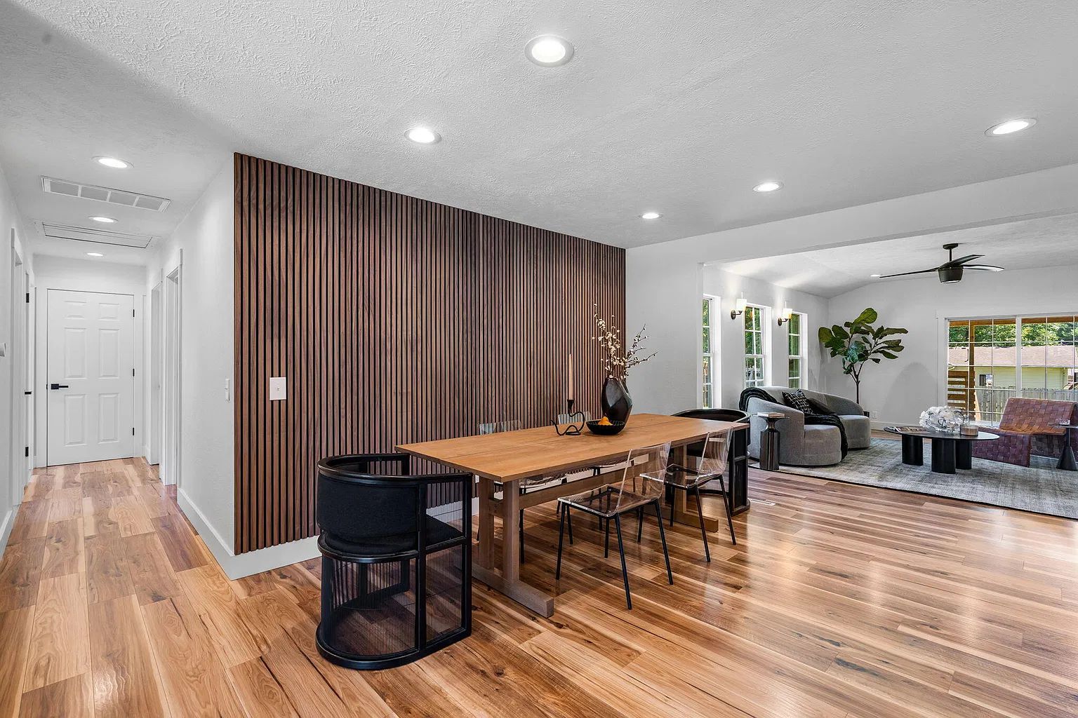 A modern interior with a dining area, a living room, and a kitchen.