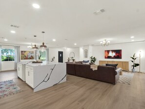 Un espacio habitable moderno con una isla de cocina, un sofá y una chimenea.