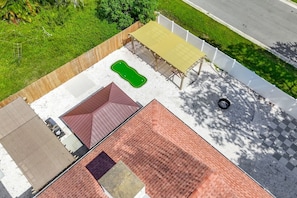Tagterrasse med pool, overdækket siddeområde og fliseterrasse.
