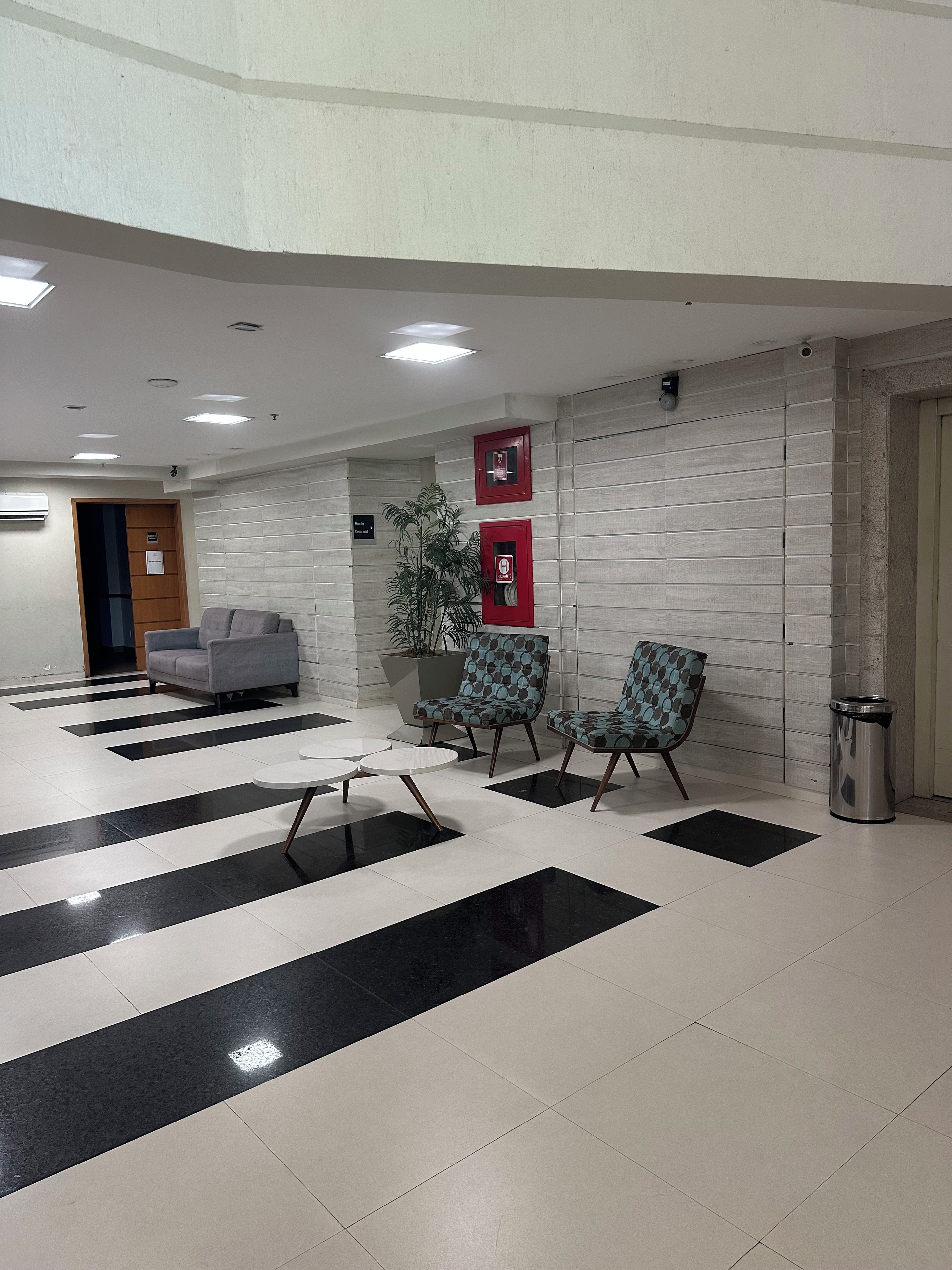 Eine Lobby mit Empfangsschalter, Sitzgelegenheiten und einem Mülleimer.