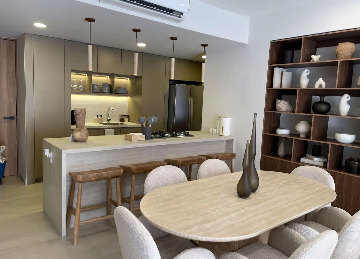 A modern kitchen with a central island, bar stools, and a dining table with chairs.
