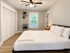 A bedroom with a bed, a ceiling fan, a window, and a closet. - Serene 3-bedroom cottage with AC in charming Wilmington (Wilmington)