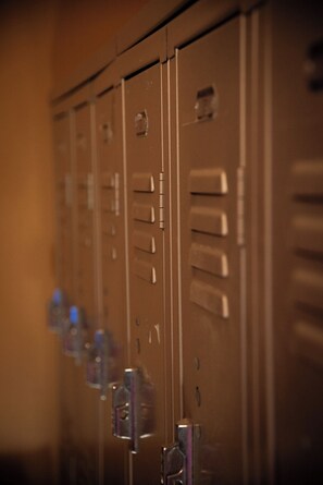 A row of metal lockers with a keyhole and a small window.