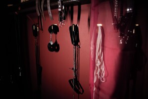 A wall with various items hanging, including keys and a black object.