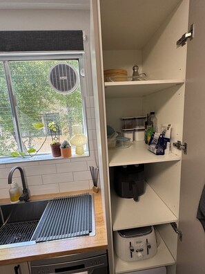 Una cocina con ventana, pileta y varios armarios.