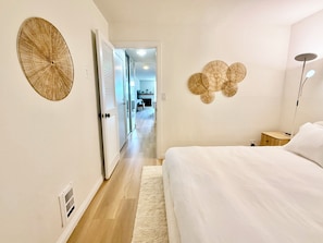 Un dormitorio con cama, mesita de noche y una lámpara de pared.