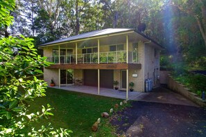 Ein zweistöckiges Haus mit Balkon, Garage und einem gepflegten Rasen.