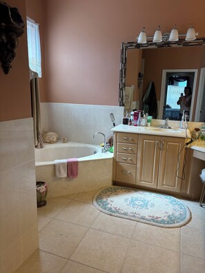 Un baño con bañera, lavamanos, espejo y retrete.