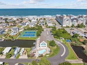 Bairro residencial com quadra de tênis, piscina e vista para o oceano.