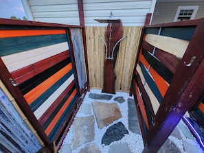 A narrow outdoor pathway with a stone and gravel ground, flanked by wooden fences with horizontal stripes. - Beautiful campground in nice North Fort Myers location Behind my house (North Fort Myers)