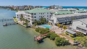Ein Hotel am Wasser mit mehreren Gebäuden, einem Schwimmbad und einer Anlegestelle.