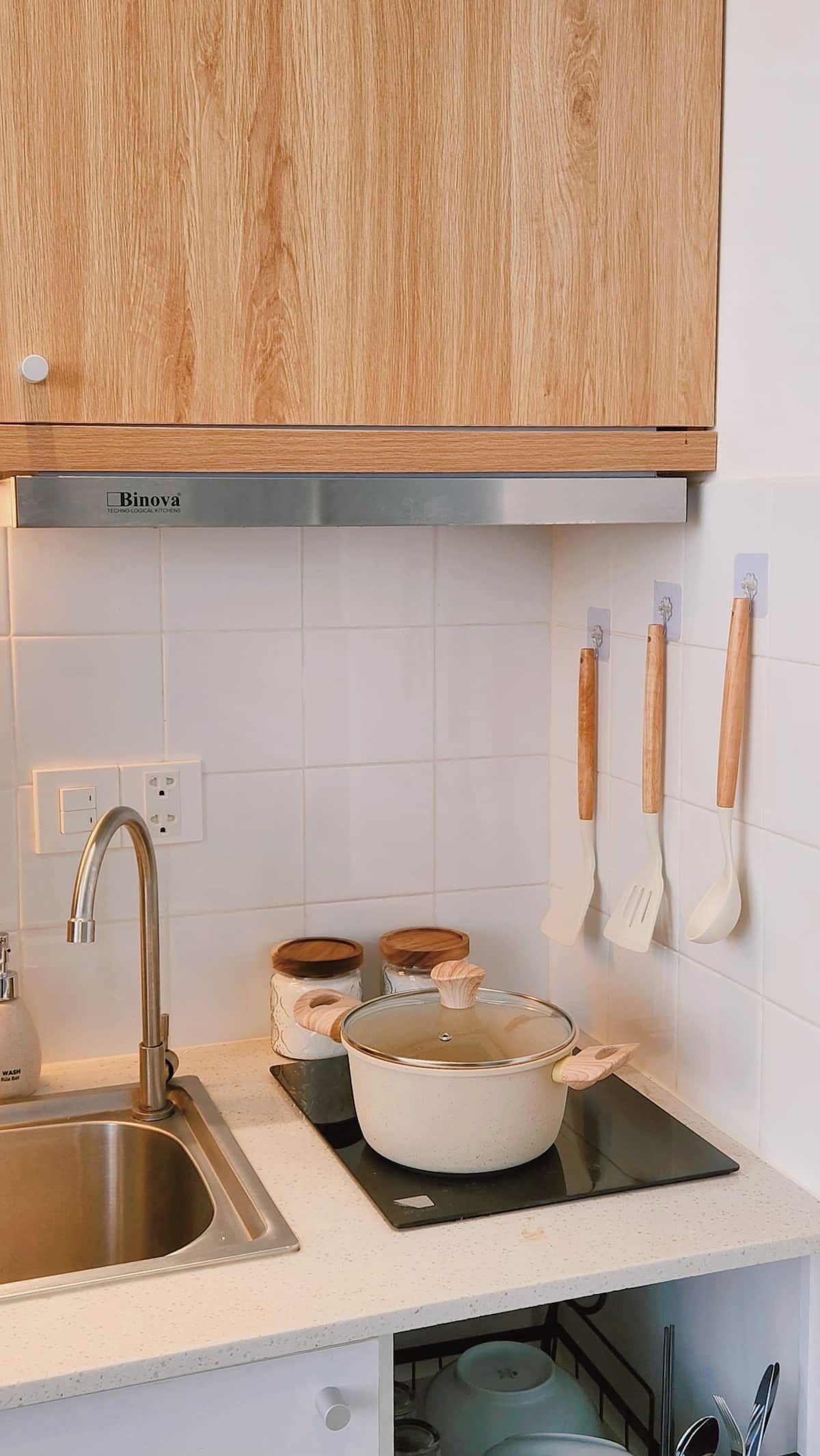 Eine Küche mit Spüle, Herd, Holzschränken und einem an der Wand befestigten Küchenutensilienhalter.