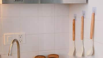 Eine Küche mit Spüle, Herd, Holzschränken und einem an der Wand befestigten Küchenutensilienhalter.