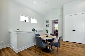Una cocina moderna con una isla central, sillas grises y una mesa de comedor.