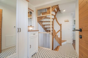 Una escalera con barandillas de madera y un interior blanco.