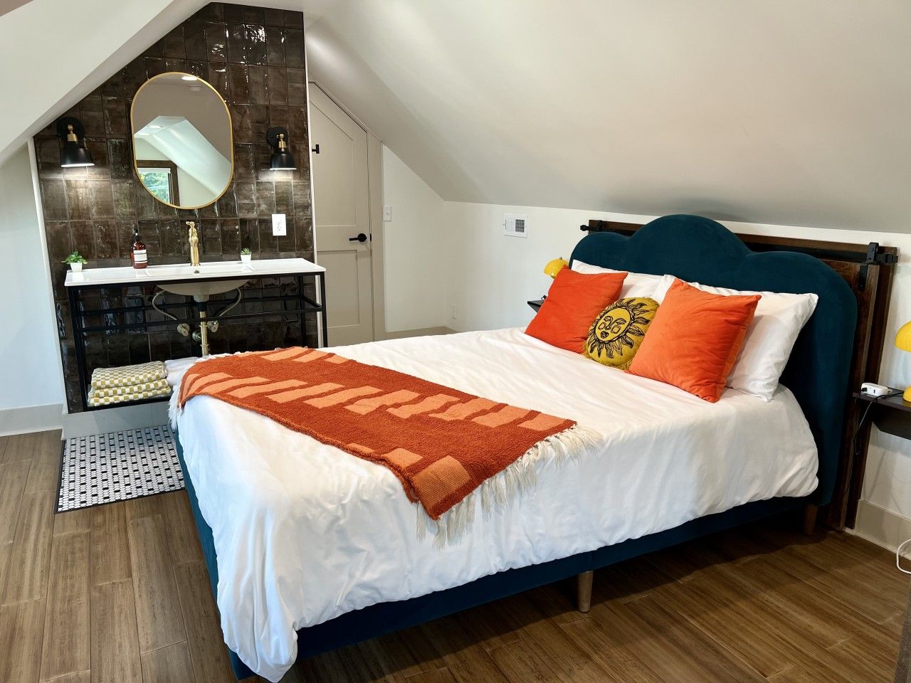 A bedroom with a bed, a dresser, a mirror, and a nightstand.