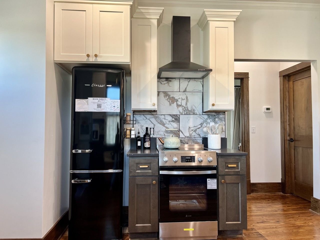 A compact kitchen with a black refrigerator, a stove, and a microwave.