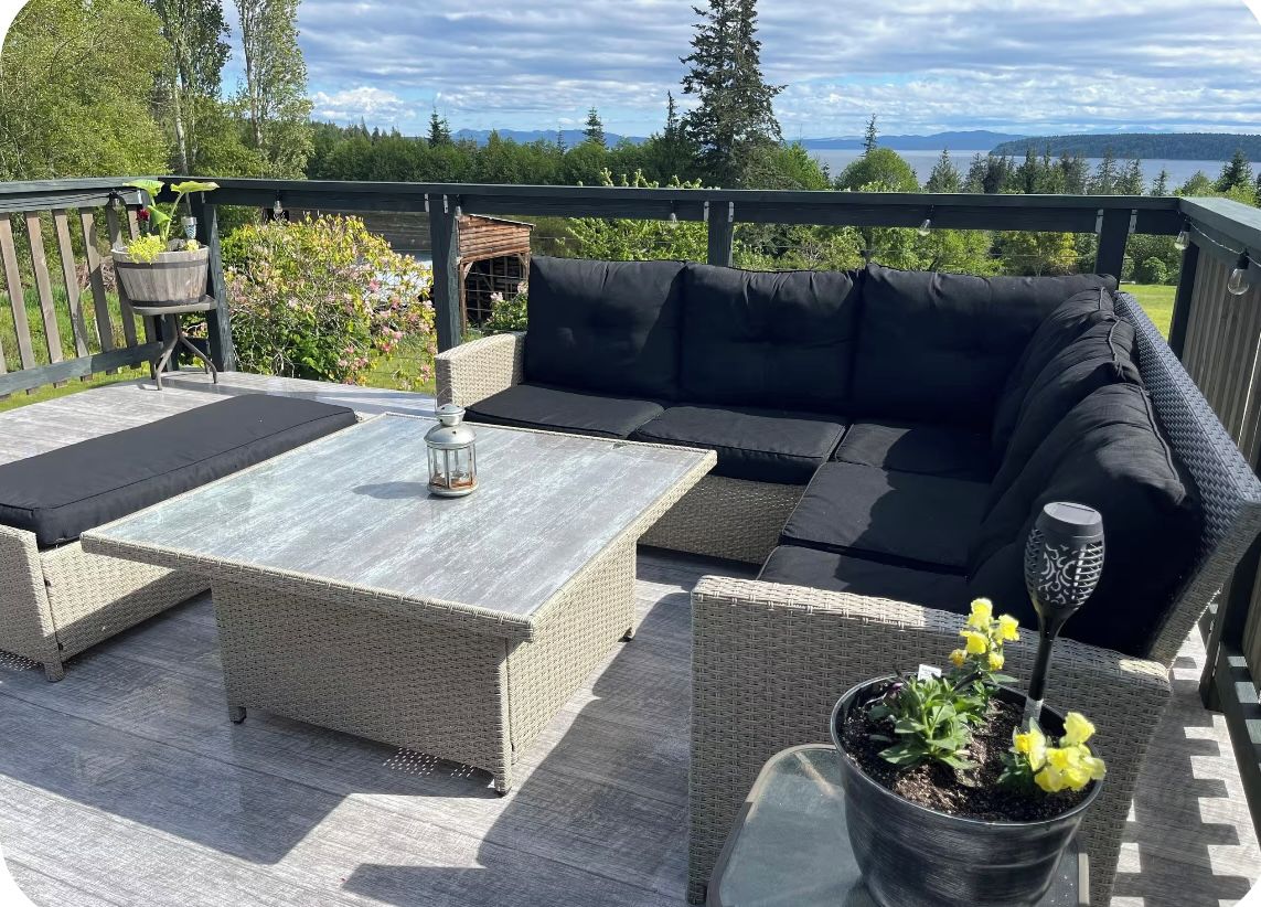 An outdoor deck with a sofa, a table, and potted plants.