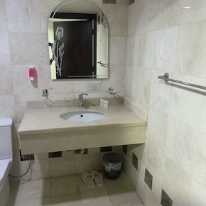 Casa de banho com lavatório, espelho e secador de mãos.
