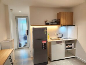 Une cuisine compacte équipée d’un réfrigérateur, d’un four à micro-ondes et d’un petit plan de travail.