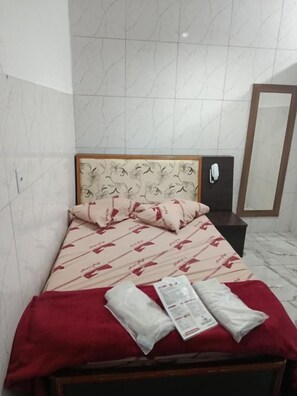 A hotel room with a bed, a nightstand, a mirror, and a red blanket. - Santo Amaro inn (São Paulo)
