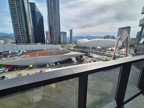 A view of a modern urban area with high-rise buildings, a stadium, and a parking lot. - Cozy Apartment for rent in Batumi! Stadium View (Batumi)