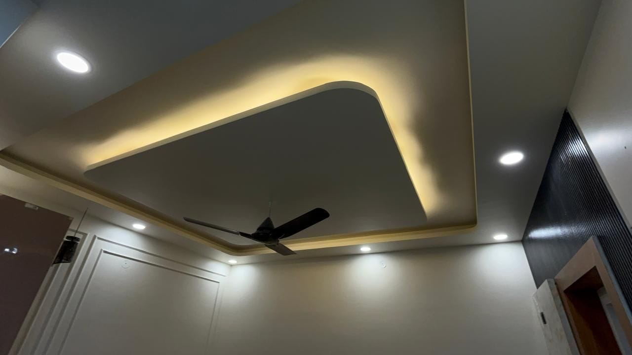 Un plafond doté d’un éclairage encastré et d’un ventilateur de plafond.