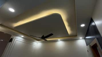Een plafond met inbouwspots en een plafondventilator.