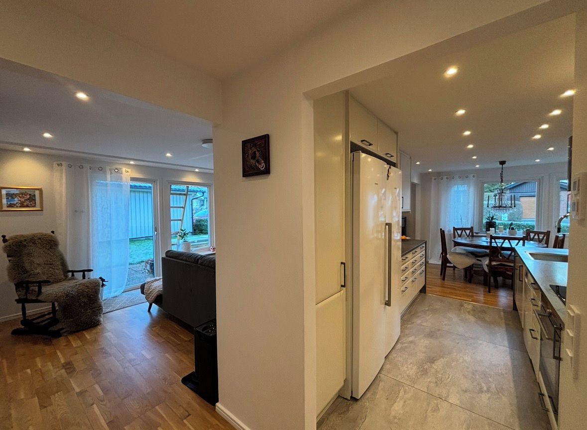 Una cocina moderna con refrigerador, mesa de comedor y sillas.