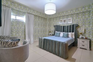 A bedroom with a bed, a bedside table, a chair, and a window with curtains. - Beachfront apartment on the 9th floor of Las Olas, Juan Dolio — panoramic ocean views, infinity pool, and 24/7 reception. (Juan Dolio)