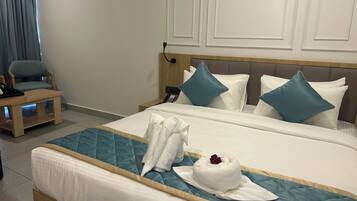 Ein Hotelzimmer mit einem Bett, einem Nachttisch, einem Sessel und einem an der Wand befestigten Telefon.