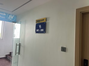 Un pasillo con un cartel que indica el tercer piso y un número de contacto.