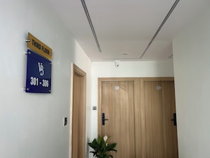 Un pasillo con un cartel que indica el tercer piso y los números de habitación 301 al 306.