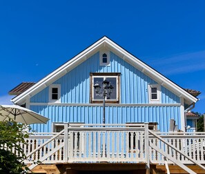 Ein zweigeschossiges Gebäude mit einem Balkon und einer weißen Brüstung.